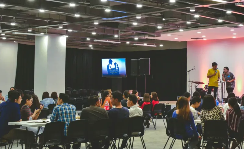 Guests seated in black chairs at a corporate event