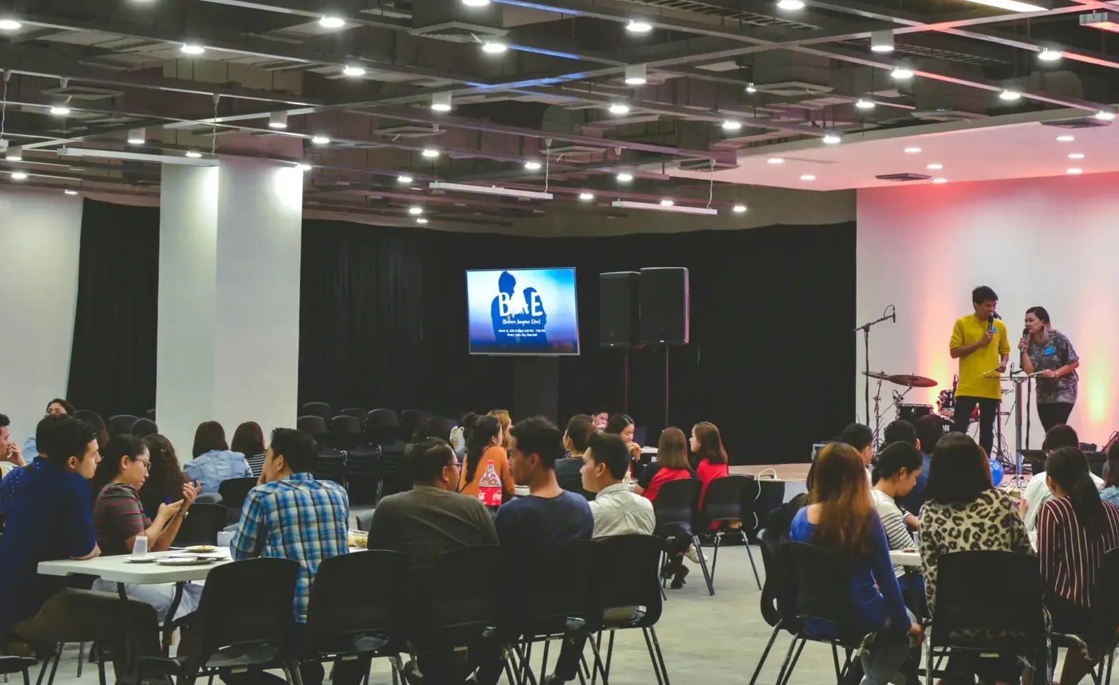 Guests seated in black chairs at a corporate event