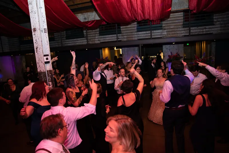 Room with red ceiling draping and guests dancing